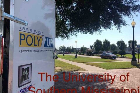 The University of Southern Mississippi campus with buildings and greenery under a clear blue sky.